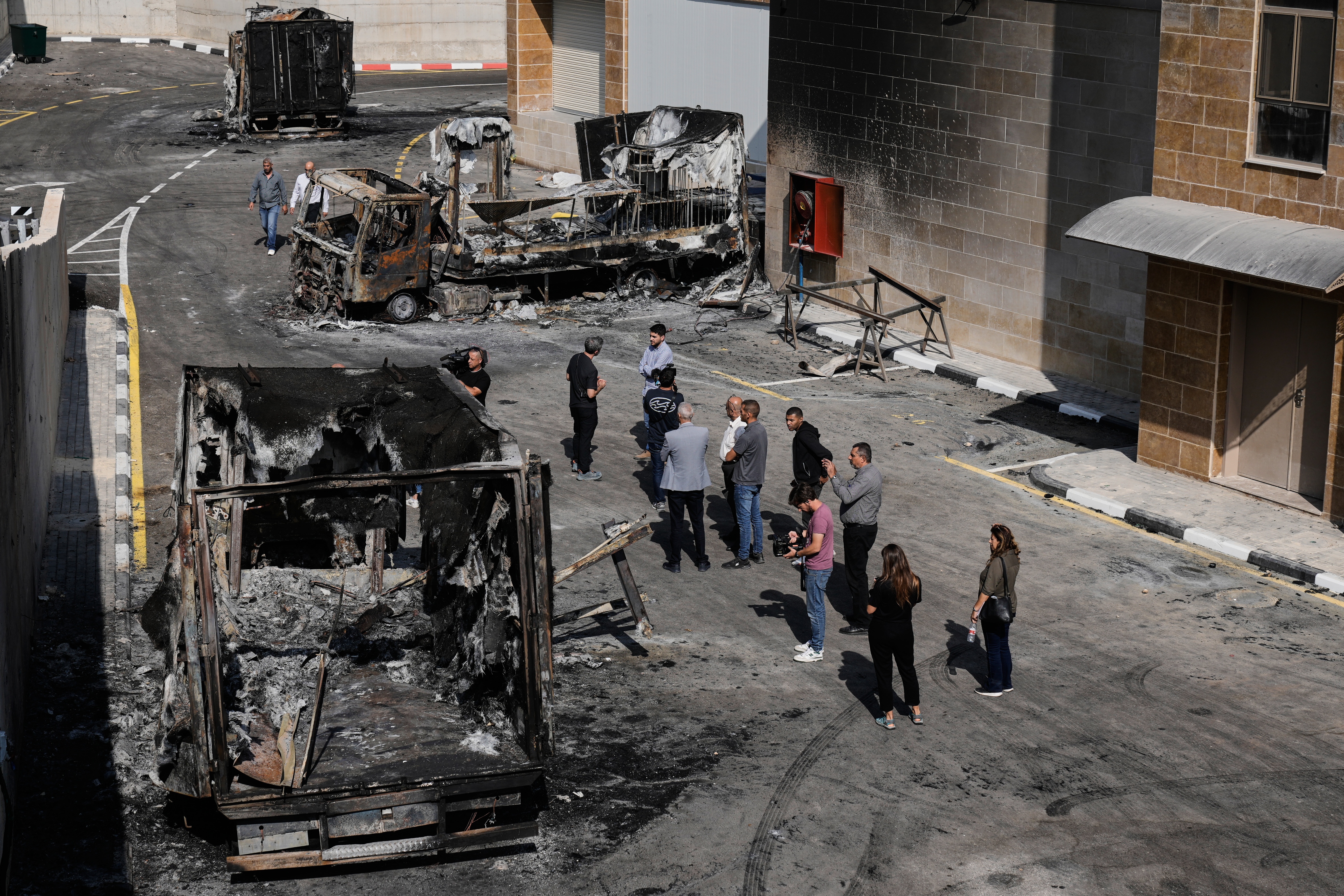 Palestinians and journalists survey damage in an industrial zone following an attack by Israeli settlers the previous day in the West Bank village of Beit Lid, near Tulkarm, Wednesday.